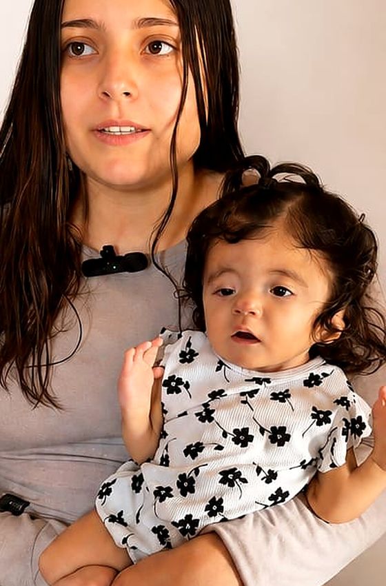 Emy en brazos de su mamá